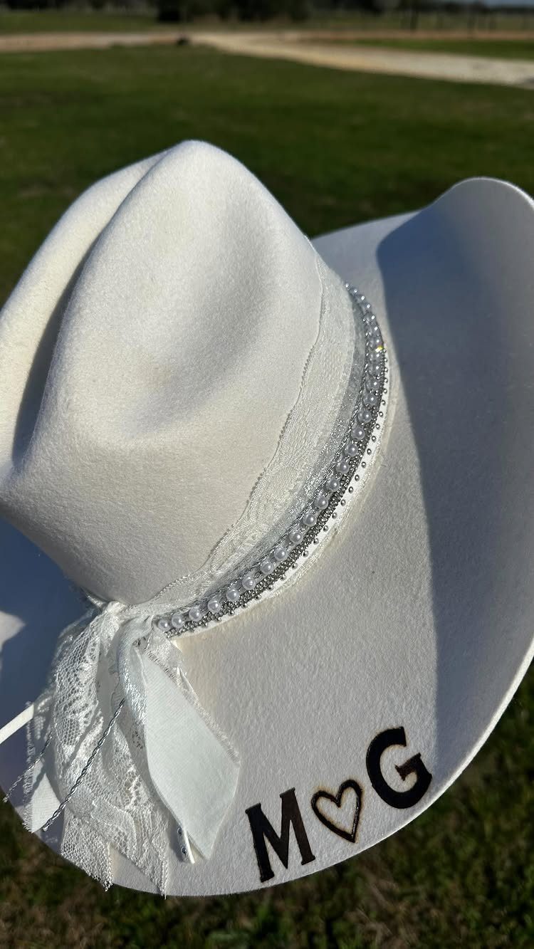 What Are the Best Western Themed Wedding Ideas? 37 Here 33 White bridal cowboy hat with rhinestones, lace bow, and initials M heart G.