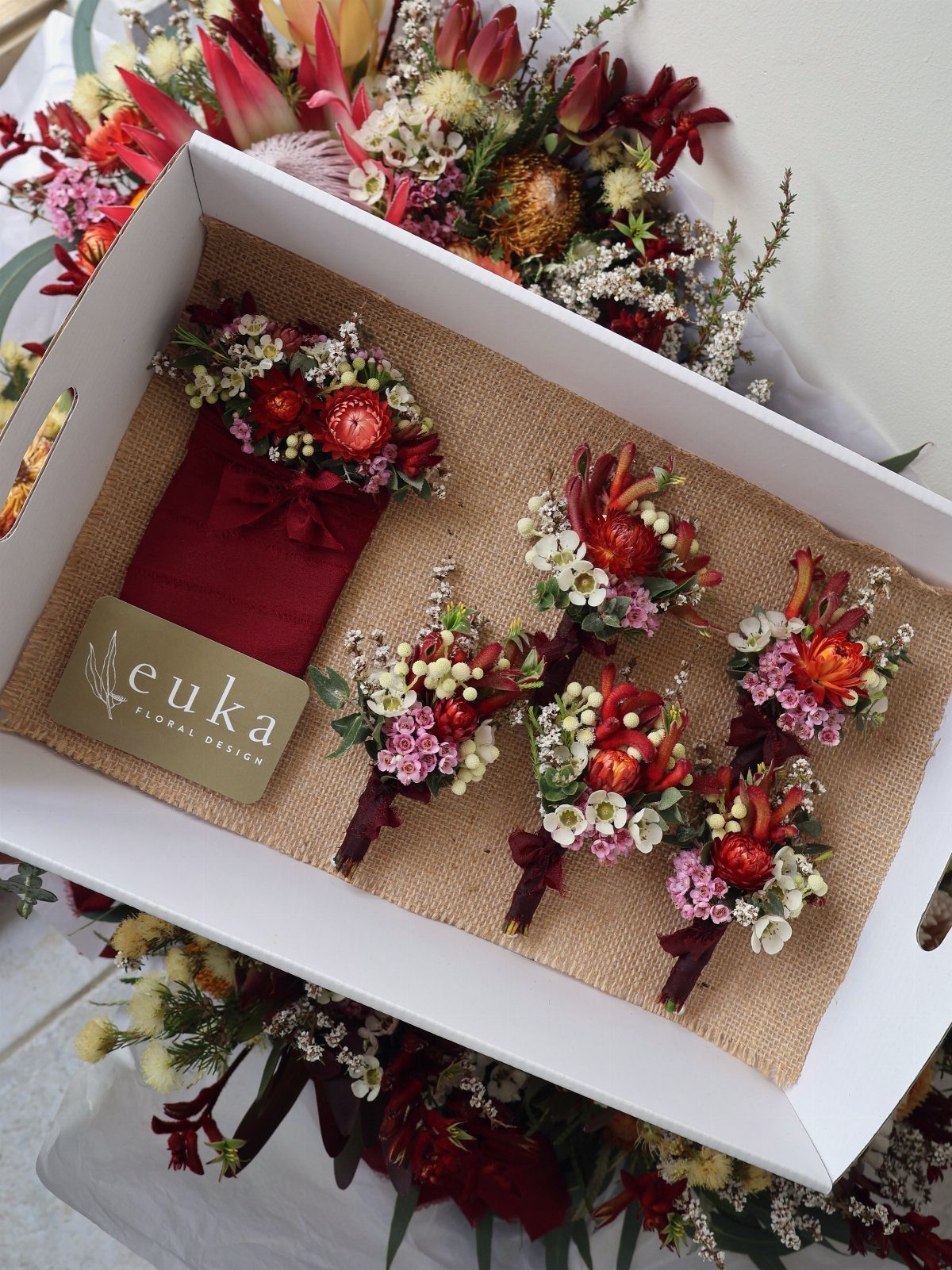 What Are the Best Western Themed Wedding Ideas? 37 Here 26 Small floral boutonnieres with red and white flowers on a burlap tray