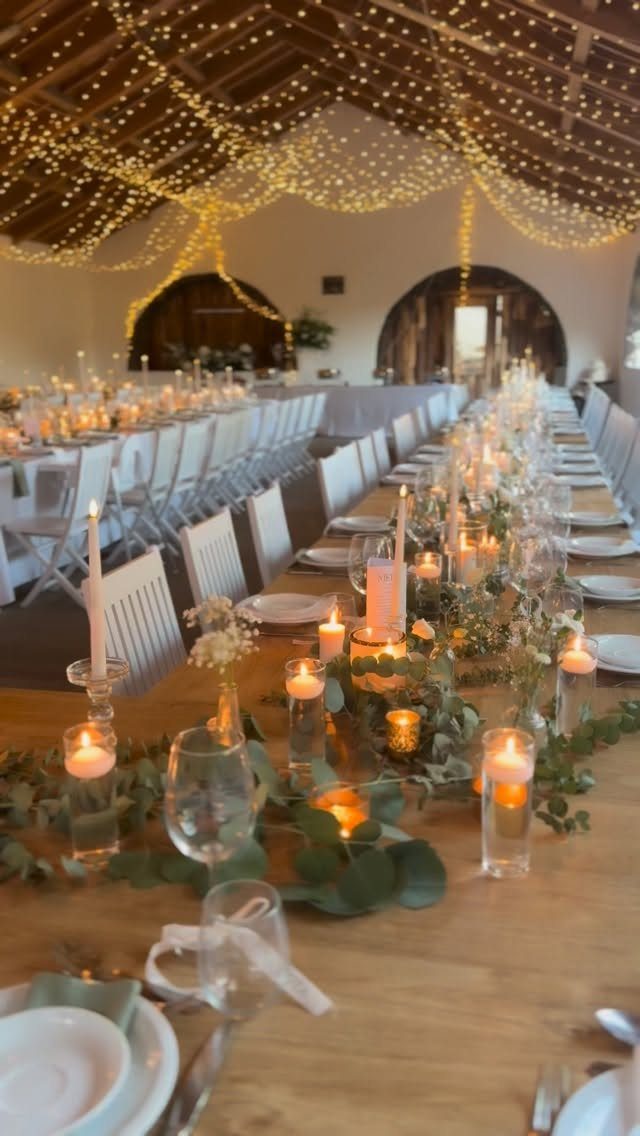 What Are the Best Western Themed Wedding Ideas? 37 Here 22 Wooden wedding table decorated with greenery, white candles, and overhead fairy lights.