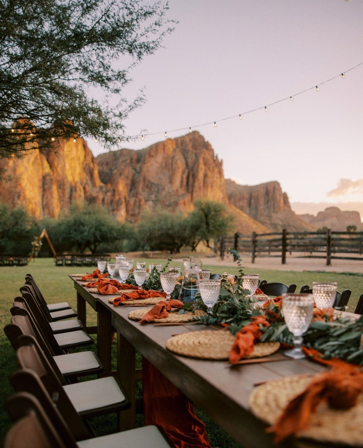 Wooden wedding table with orange accents set against a backdrop of red rock mountains.