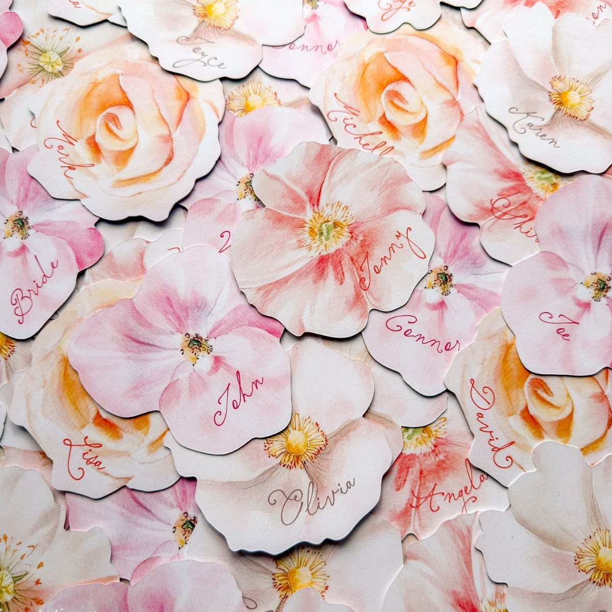 Whimsical Wildflower Wedding: 7 Decor Ideas That Feel Grown, Not Styled 5 Paper wildflower cutouts with handwritten names scattered in a layered, floral arrangement.