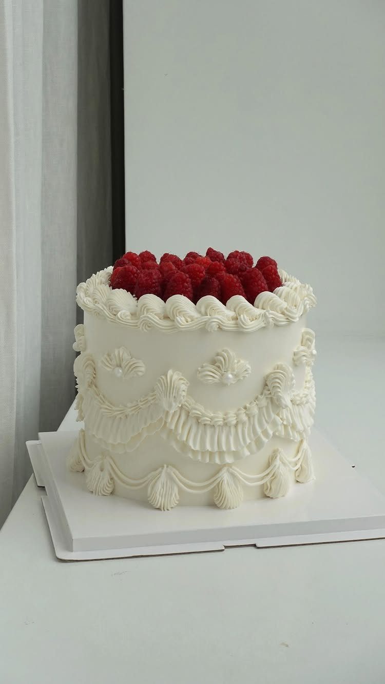 9 White Buttercream Cake Ideas That Look Bakery-Worthy at Home 8 White buttercream cake decorated with intricate piped swirls and topped with fresh red raspberries.