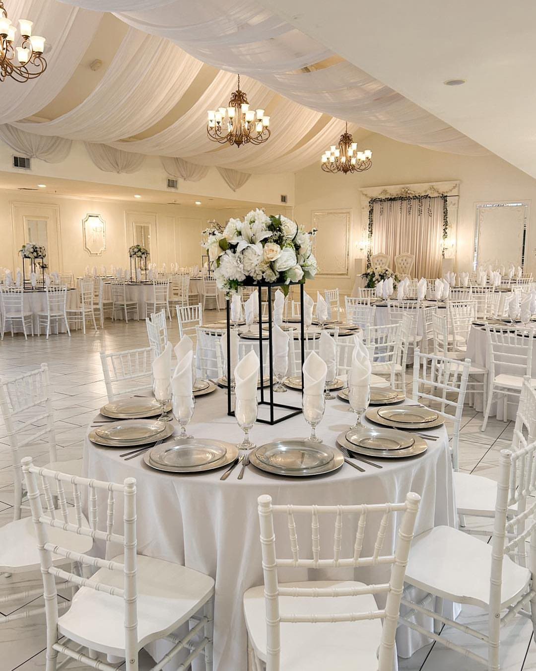 White Wedding Ideas: 23 Elegant Details for Your Big Day 8 White ballroom with draped ceilings, gold chandeliers, and elegant white table settings.