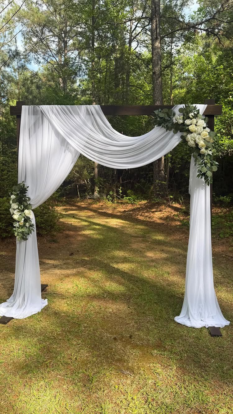 White Wedding Ideas: 23 Elegant Details for Your Big Day 13 Wooden wedding arch draped in white fabric and adorned with white floral arrangements.
