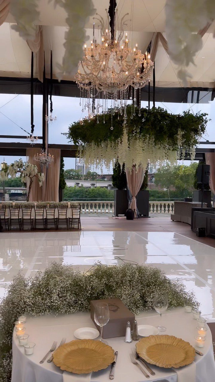 White Wedding Ideas: 23 Elegant Details for Your Big Day 18 Glossy white dance floor in a wedding venue with a crystal chandelier and greenery.
