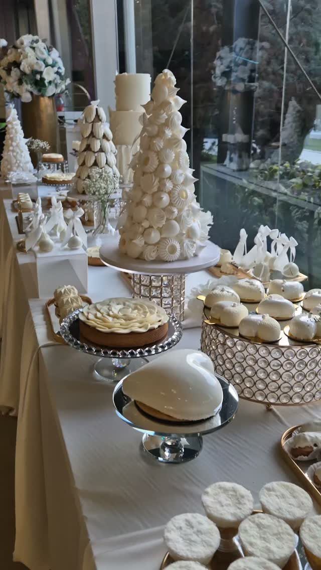 White Wedding Ideas: 23 Elegant Details for Your Big Day 4 White dessert table with a conical cake, macarons, and heart-shaped sweets on stands.